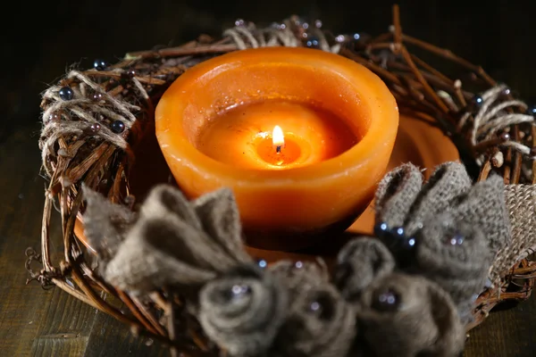 Brennende Kerze mit Adventskranz auf Holzgrund — Stockfoto