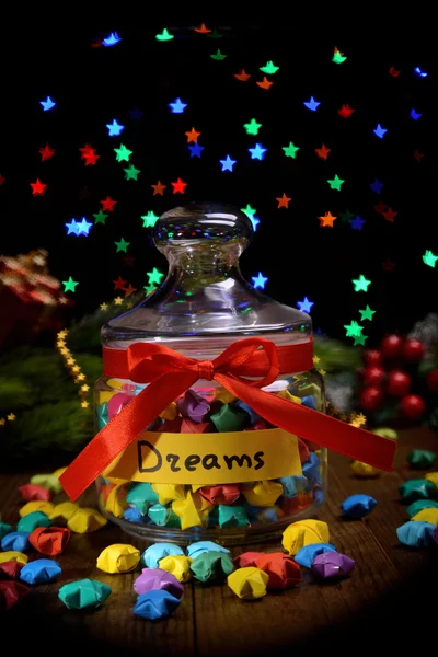 Paper stars with dreams on table on dark background — Stock Photo, Image
