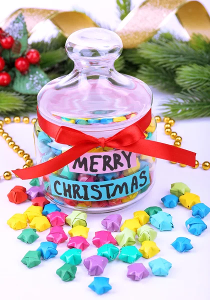 Paper stars with dreams in jar on white background — Stock Photo, Image