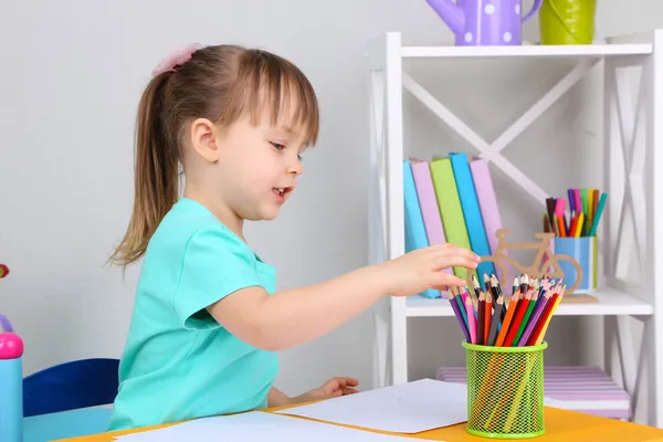 Petite fille dessine assis à table dans la chambre — Photo