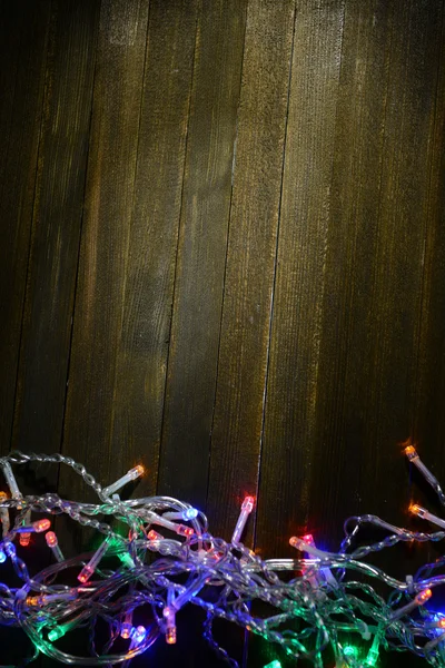 Christmas lights on wooden background — Stock Photo, Image