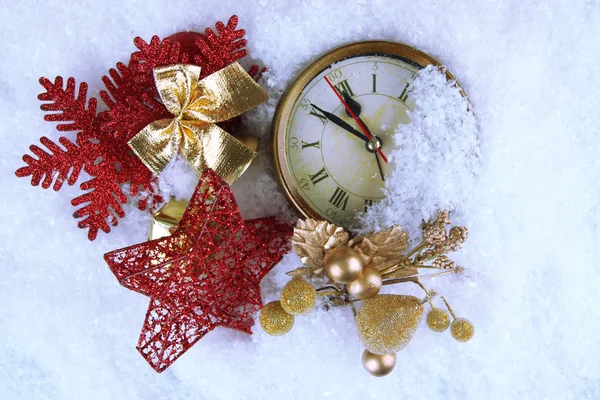 Clock and Christmas decorations under snow close up — Stock Photo, Image