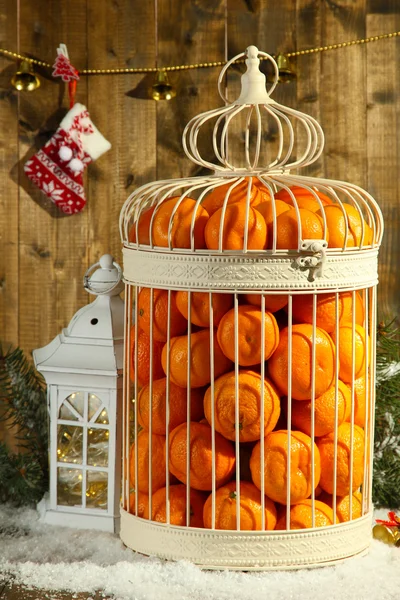 橘子装饰圣诞装饰，木制的背景上的笼子里 — 图库照片