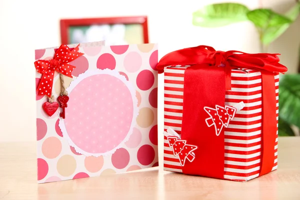 Gift with card on table on room background — Stock Photo, Image
