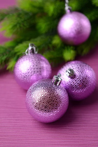 Christmas balls on fir tree, on color background — Stock Photo, Image