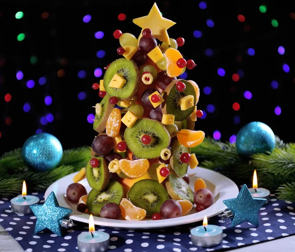 Obst-Weihnachtsbaum auf Tisch auf dunklem Hintergrund — Stockfoto