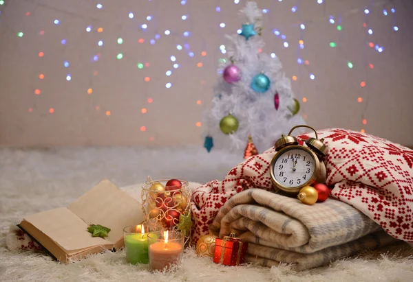 Composition avec plaids, bougies et décorations de Noël, sur tapis blanc sur fond lumineux — Photo