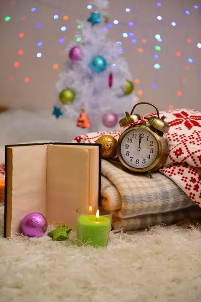 Složení s plédy, svíčky a vánoční ozdoby, na bílém koberci na světlé pozadí — Stock fotografie