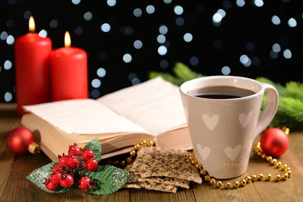 Samenstelling van boek met kop van koffie en Kerst decoraties op tafel op donkere achtergrond — Stockfoto