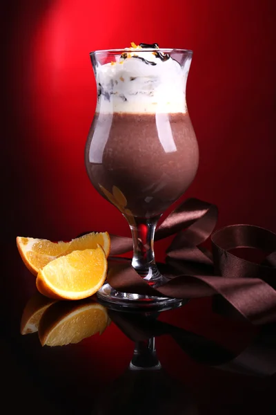 Sobremesa saborosa com chocolate, creme e molho de laranja, no fundo de cor escura — Fotografia de Stock