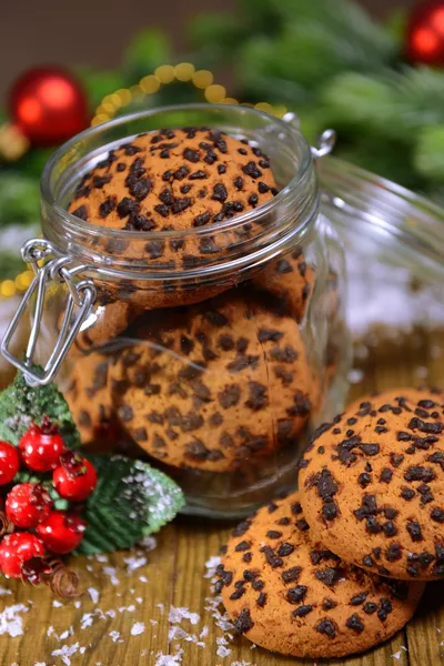 Deliciosos biscoitos de Natal em frasco na mesa sobre fundo marrom — Fotografia de Stock