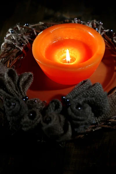 Brennende Kerze mit Adventskranz auf Holzgrund — Stockfoto