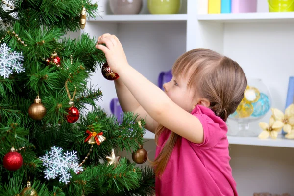 附近在房间里的圣诞树上的小女孩 — 图库照片