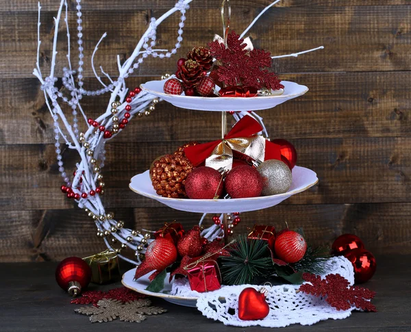 Christmas decorations on dessert stand, on wooden background — Stock Photo, Image