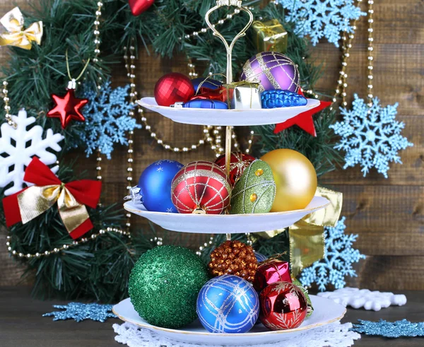 Christmas decorations on dessert stand, on color wooden background — Stock Photo, Image