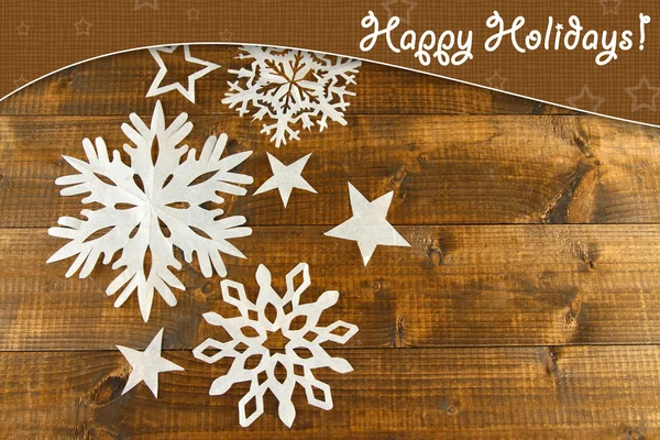 Beautiful paper snowflakes on wooden background — Stock Photo, Image