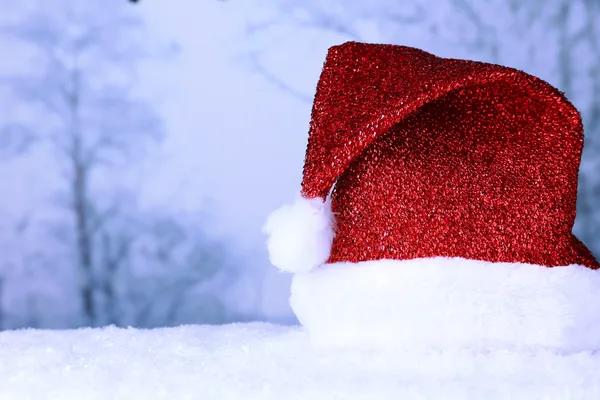 圣诞老人的帽子，在冬天背景上的雪上 — 图库照片