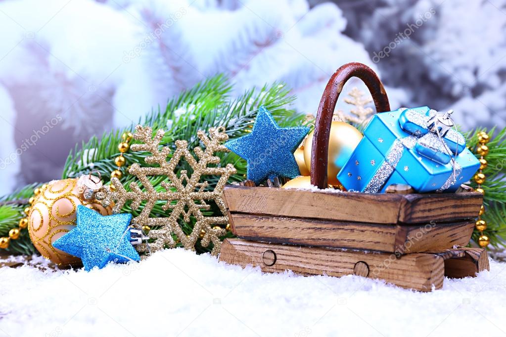 Composition with Christmas decorations in basket, fir tree on light background