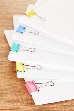 ahşap masa üzerinde bağlayıcı klipleri içeren belgeler