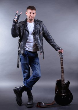 koyu renk arka plan üzerinde gitar ile genç müzisyen