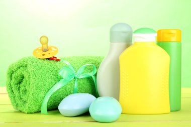 Bebek kozmetik, pembe ve yeşil zemin üzerine ahşap masa üstünde havlu