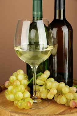 şarap şişeleri, beyaz şarap, üzüm, renkli arka plan üzerinde ahşap varil üzerinde kompozisyon