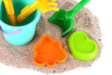 Çocukların oyuncakları kum üzerinde beyaz izole üzerinde