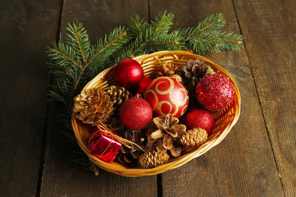 Decoraciones navideñas en cesta y ramas de abeto sobre fondo de madera —  Fotos de Stock