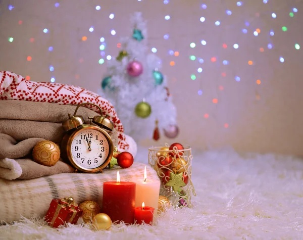 Composition avec plaids, bougies et décorations de Noël, sur tapis blanc sur fond lumineux — Photo