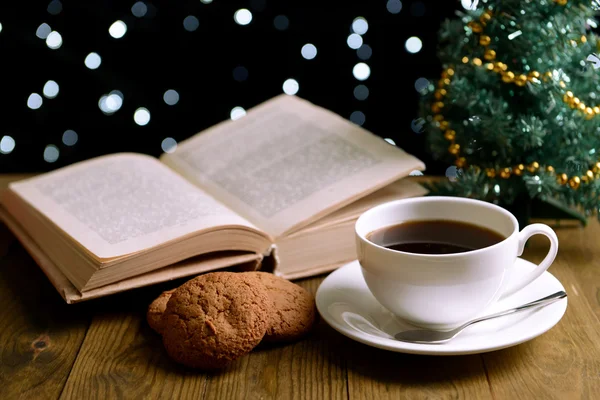 Состав книги с чашкой кофе и рождественскими украшениями на столе на темном фоне — стоковое фото