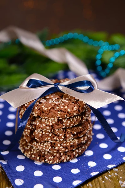 Heerlijke kerstkoekjes in pot op tafel op bruine achtergrond — Stockfoto