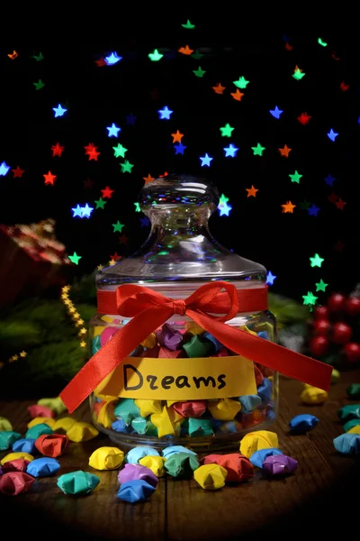 Estrelas de papel com sonhos na mesa no fundo escuro — Fotografia de Stock