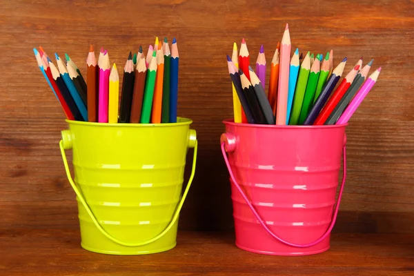 Lápices de colores en dos cubos sobre fondo de madera — Foto de Stock