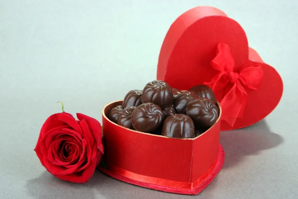Doces de chocolate em caixa de presente, em fundo cinza — Fotografia de Stock