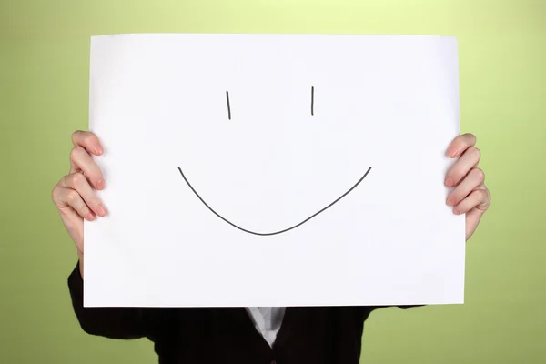 Woman holding paper with smile, on color background — Stock Photo, Image