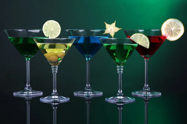 Coquetéis alcoólicos em copos de martini em fundo verde escuro — Fotografia de Stock