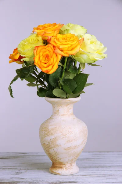 Beautiful bouquet of roses in vase on table on gray background — Stock Photo, Image