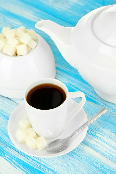 Tasse Kaffee, Teekanne und Zuckerdose auf farbigem Holzhintergrund — Stockfoto