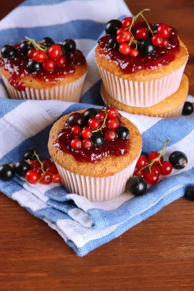 Tasty muffins with berries on wooden table — Stock Photo, Image