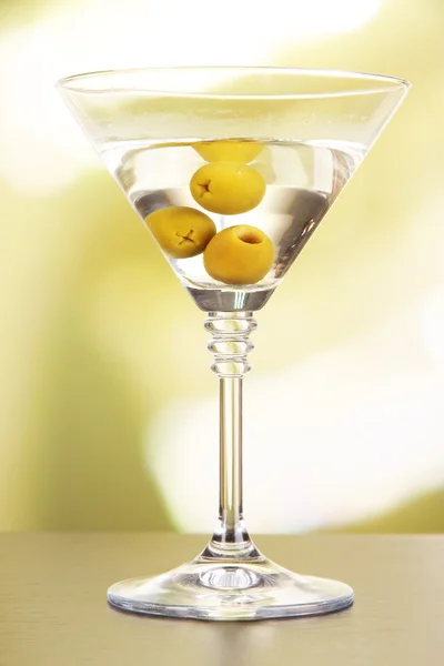Martini con aceitunas verdes en la mesa en bar —  Fotos de Stock