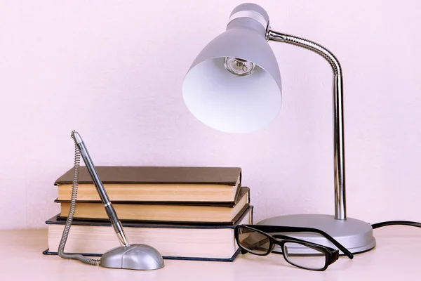 Stolní lampa s knihami na stole v místnosti — Stock fotografie