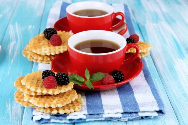 Tazze di tè con biscotti e bacche sul tavolo primo piano — Foto Stock