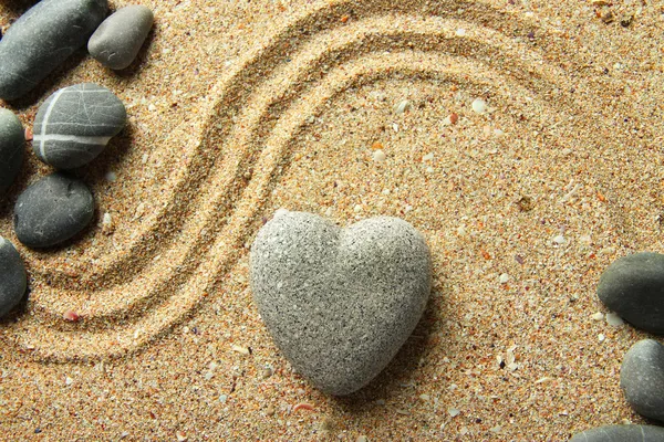 Pedra zen cinza em forma de coração, sobre fundo de areia — Fotografia de Stock