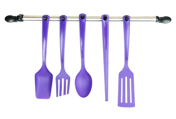 Plastic kitchen utensils on silver hooks isolated on white — Stock Photo, Image