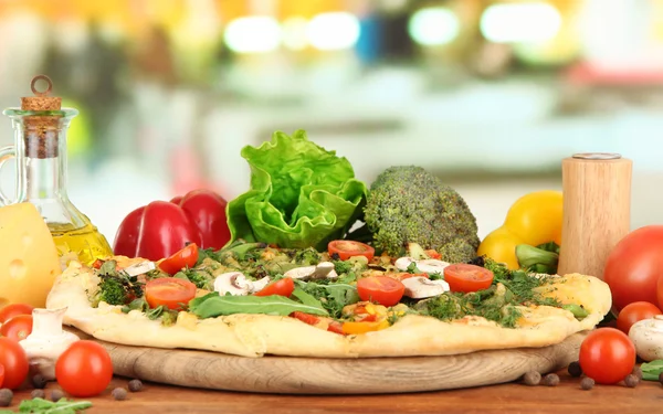 Ízletes vegetáriánus pizza és zöldség fából készült asztal — Stock Fotó