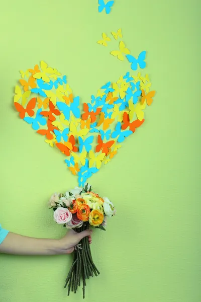 Papper fjärilar flyga ut blommor på grön vägg bakgrund — Stockfoto