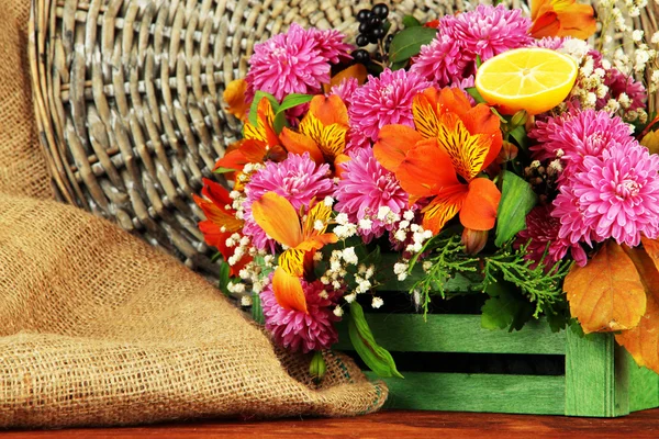 Composição de flores em caixa na mesa no fundo de vime — Fotografia de Stock
