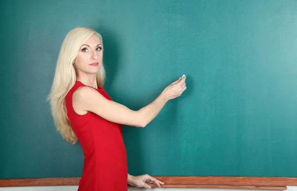 School teacher writes in chalk on blackboard — Stock Photo, Image