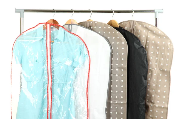 Clothes in cases for storing on hangers, on gray background — Stock Photo, Image