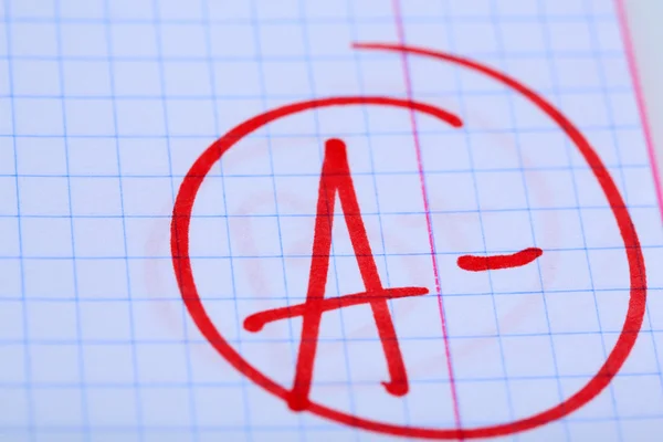 Grade A- written on an exam paper — Stock Photo, Image